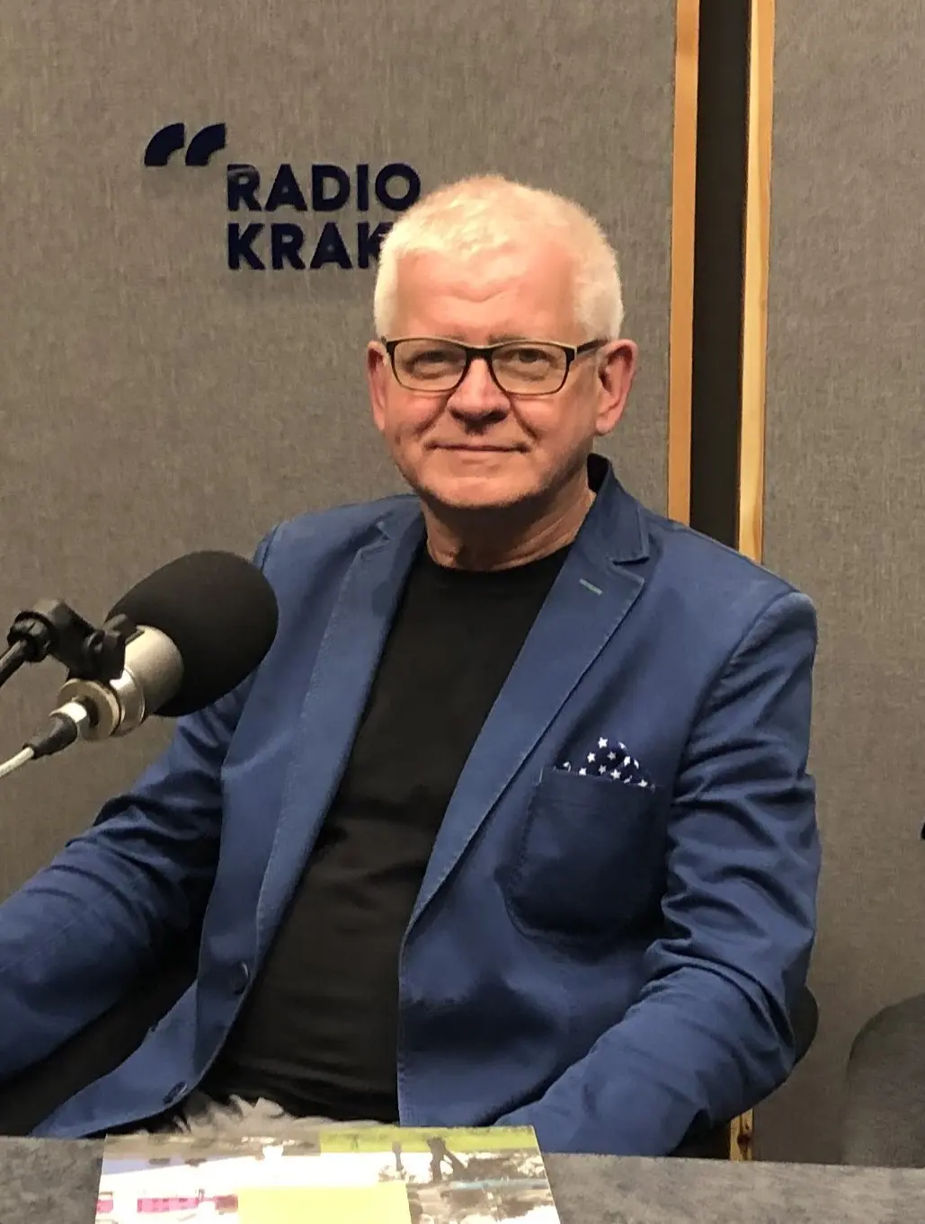 Elegancko ubrany mężczyzna w studiu radiowym.