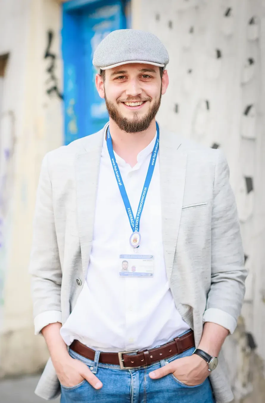 Młody mężczyzna uśmiechający się do zdjęcia.