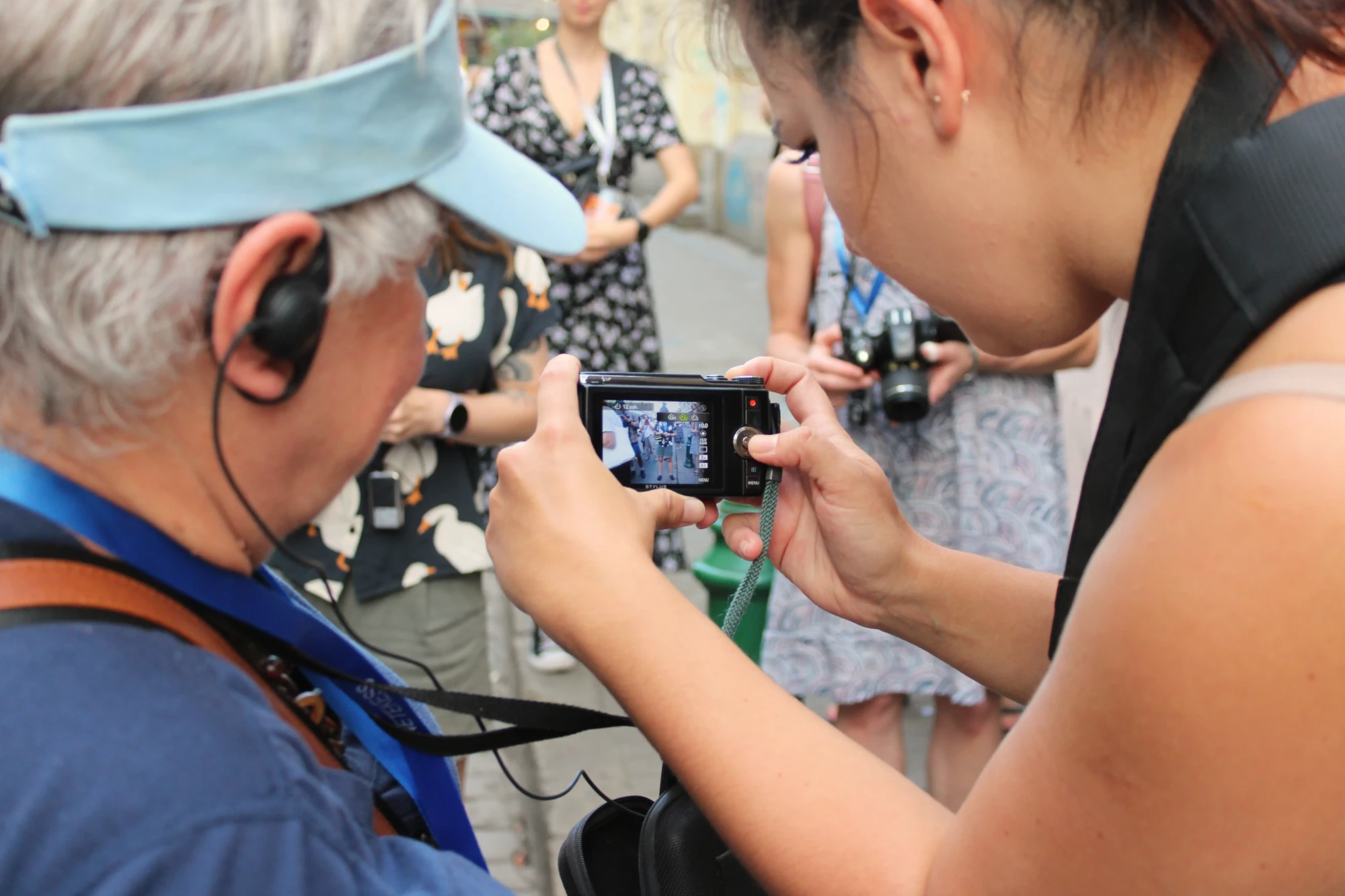 Dwie kobiety patrzą na wyświetlacz aparatu fotograficznego.