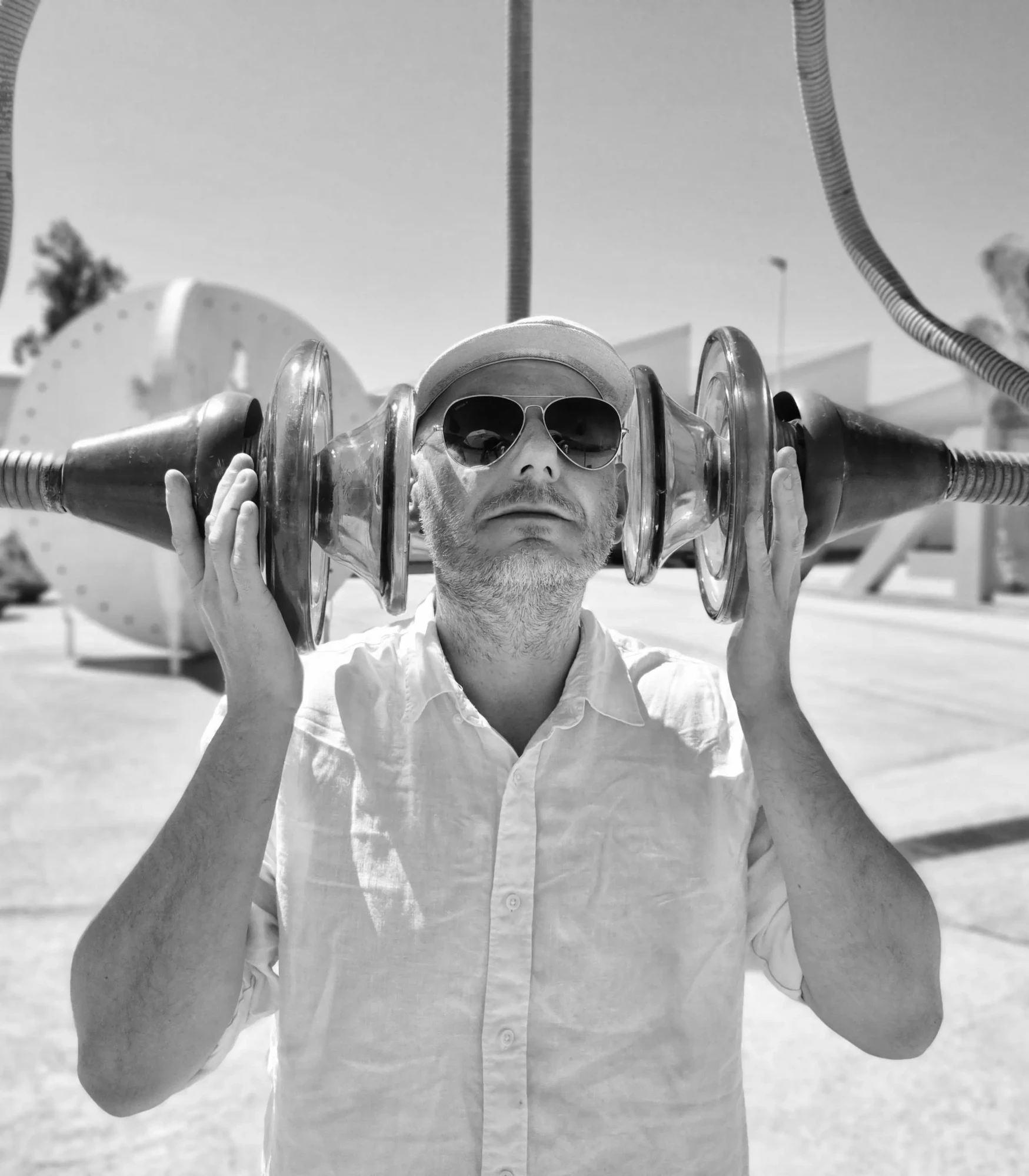 Czarno-białe zdjęcie mężczyzny, pozującego ze szklaną rzeźbą.