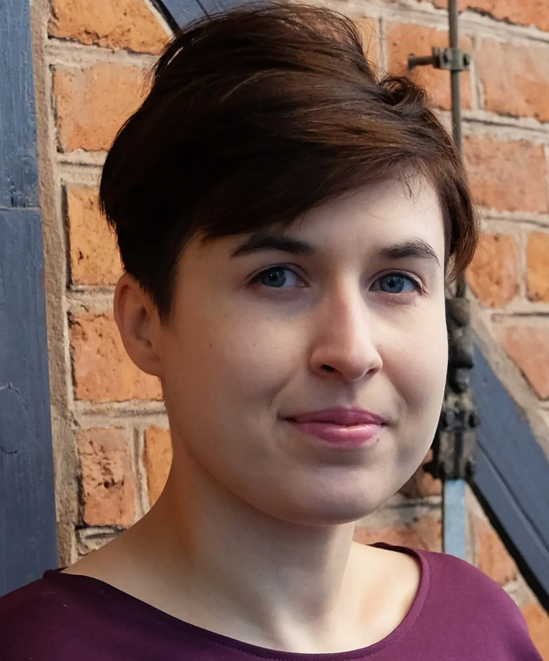 Zdjęcie portretowe kobiety z krótkimi, ciemnymi włosami.